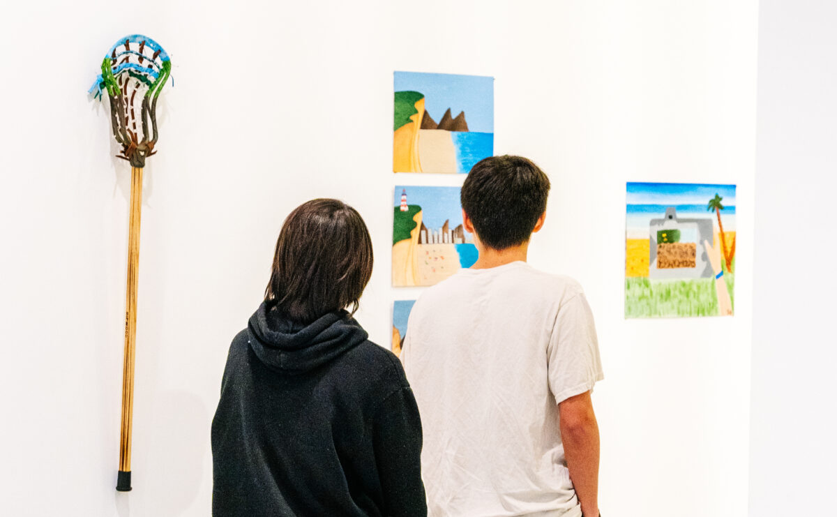 Teens look at art.