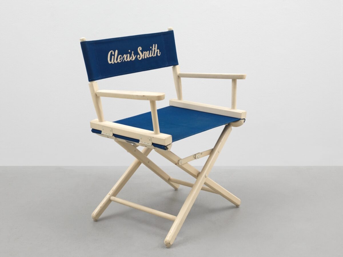 A directors chair with Alexis Smith printed on the blue fabric.