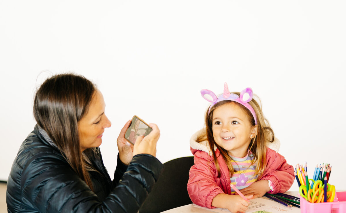 A parent takes a photo of their child.