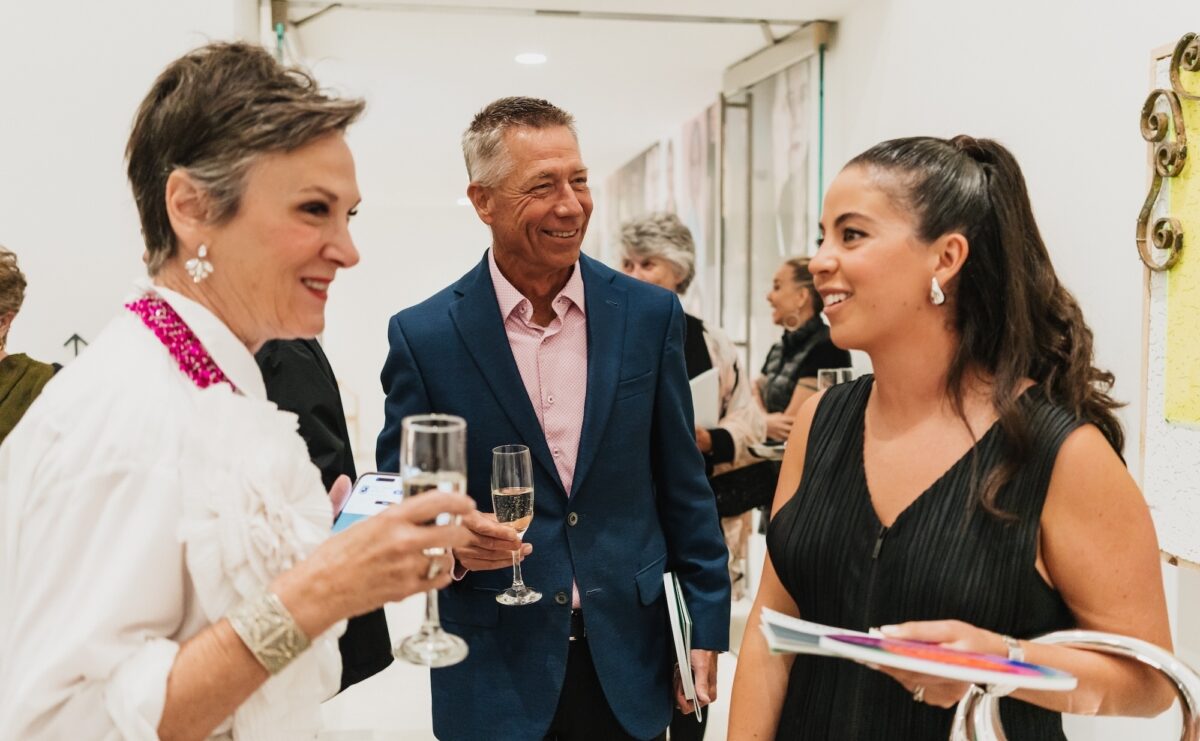 Three people mingling in the gallery.