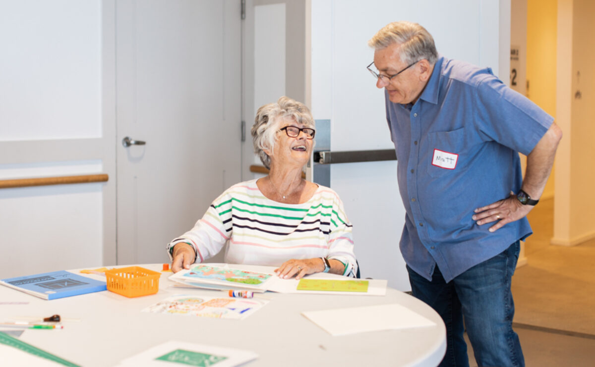 Two people creating artwork in a fun environment. They are both older adults.