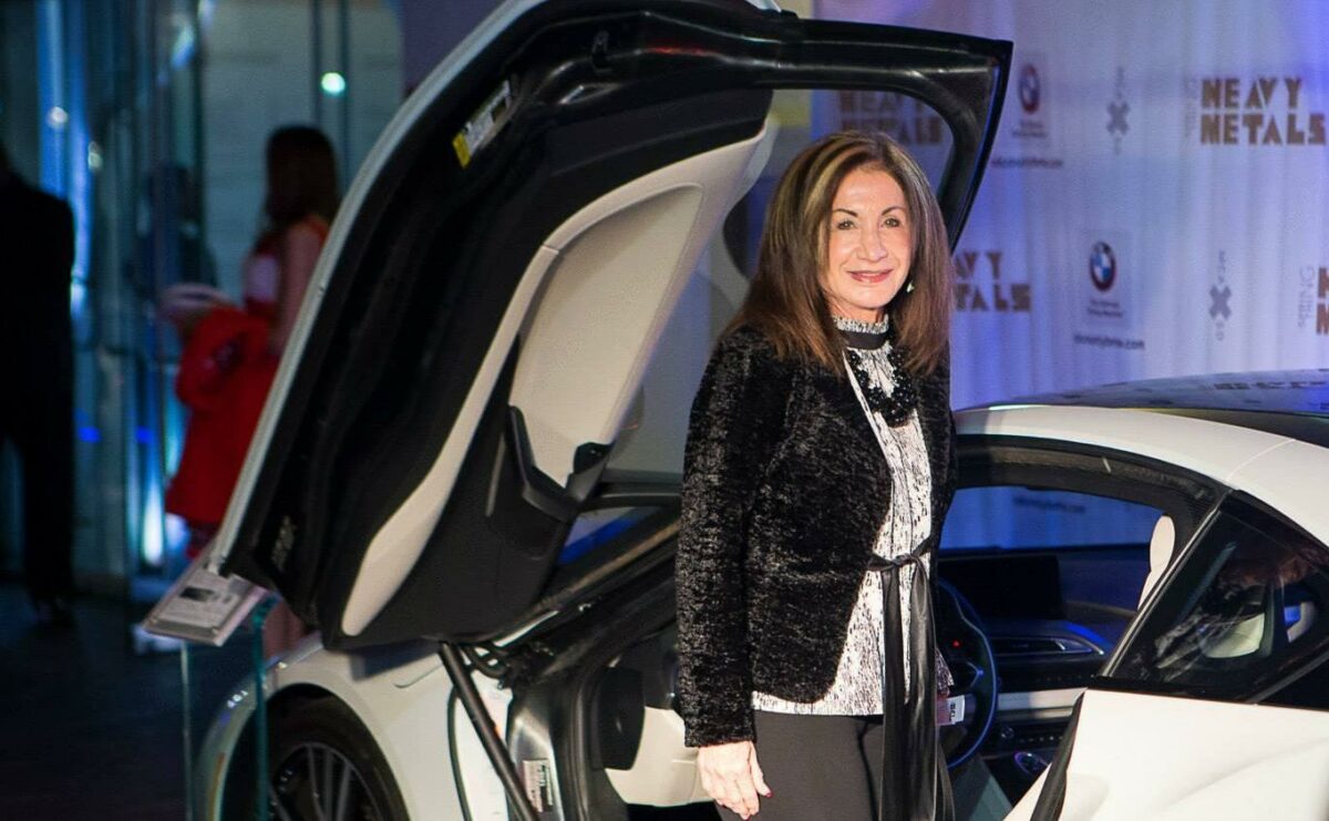 Lady poses in front of a futuristic vehicle.