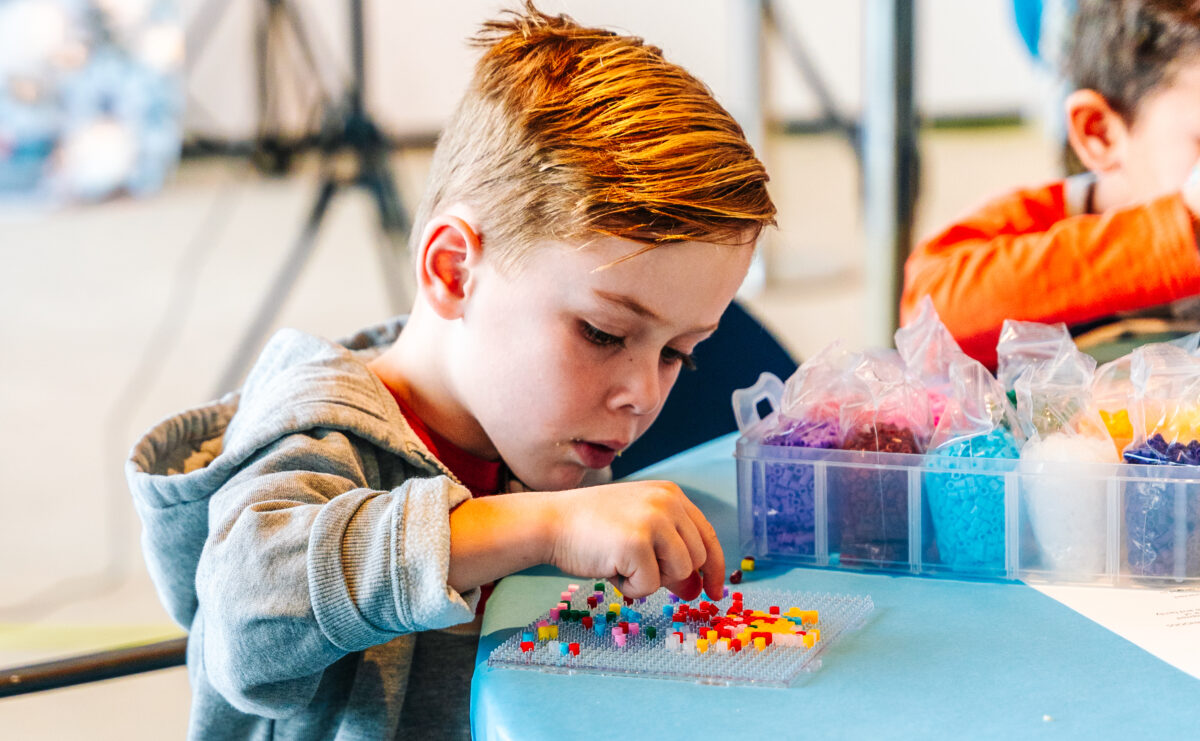 A child with beads making art