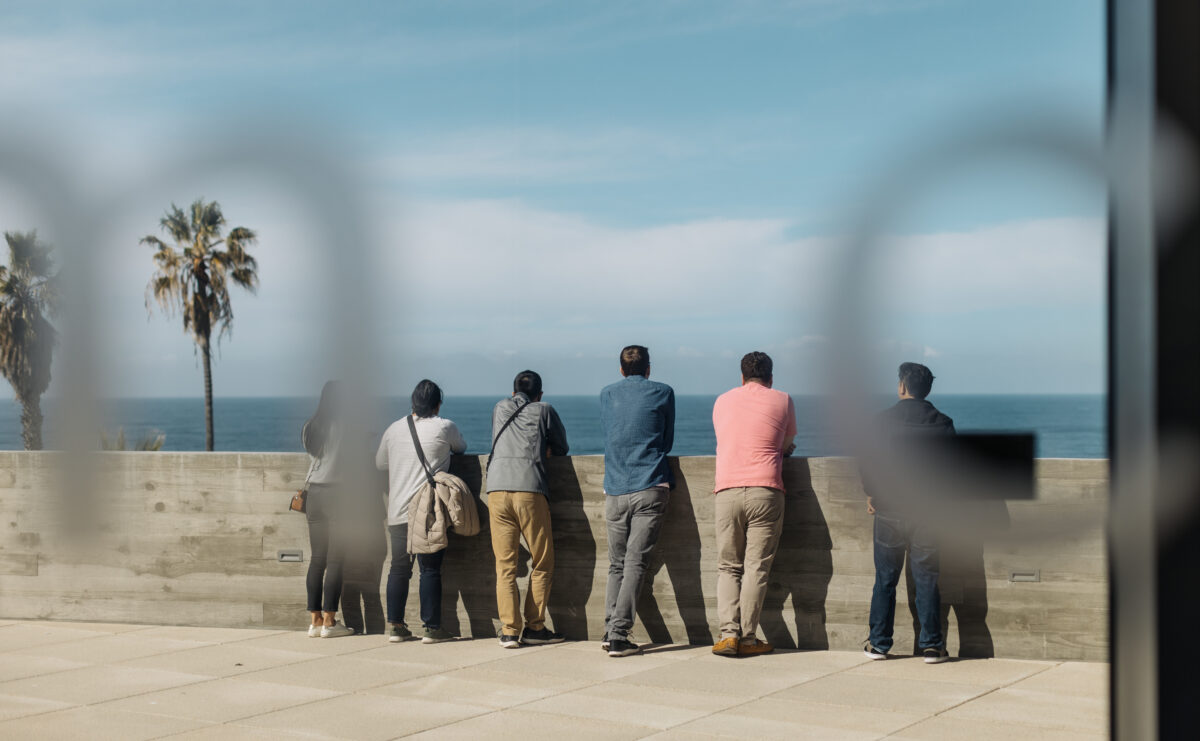 People stand next to each other on a terrace.