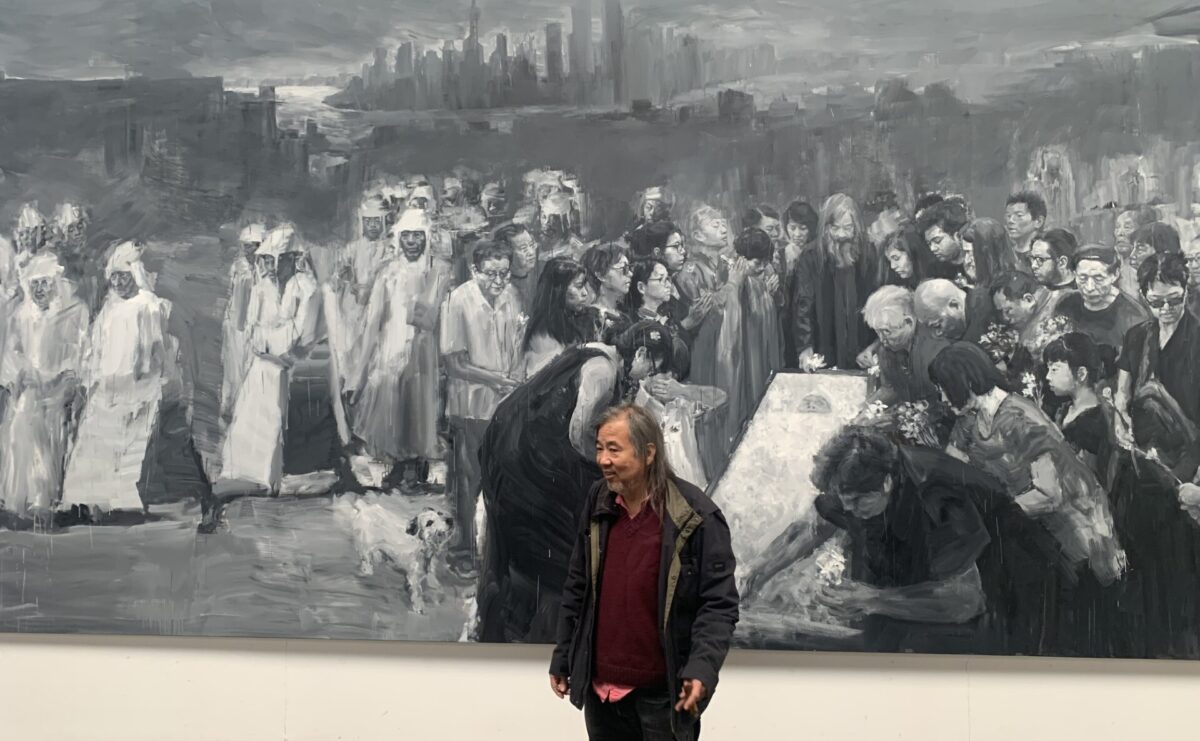 Yan Pei-Ming in front of their large canvas artwork.