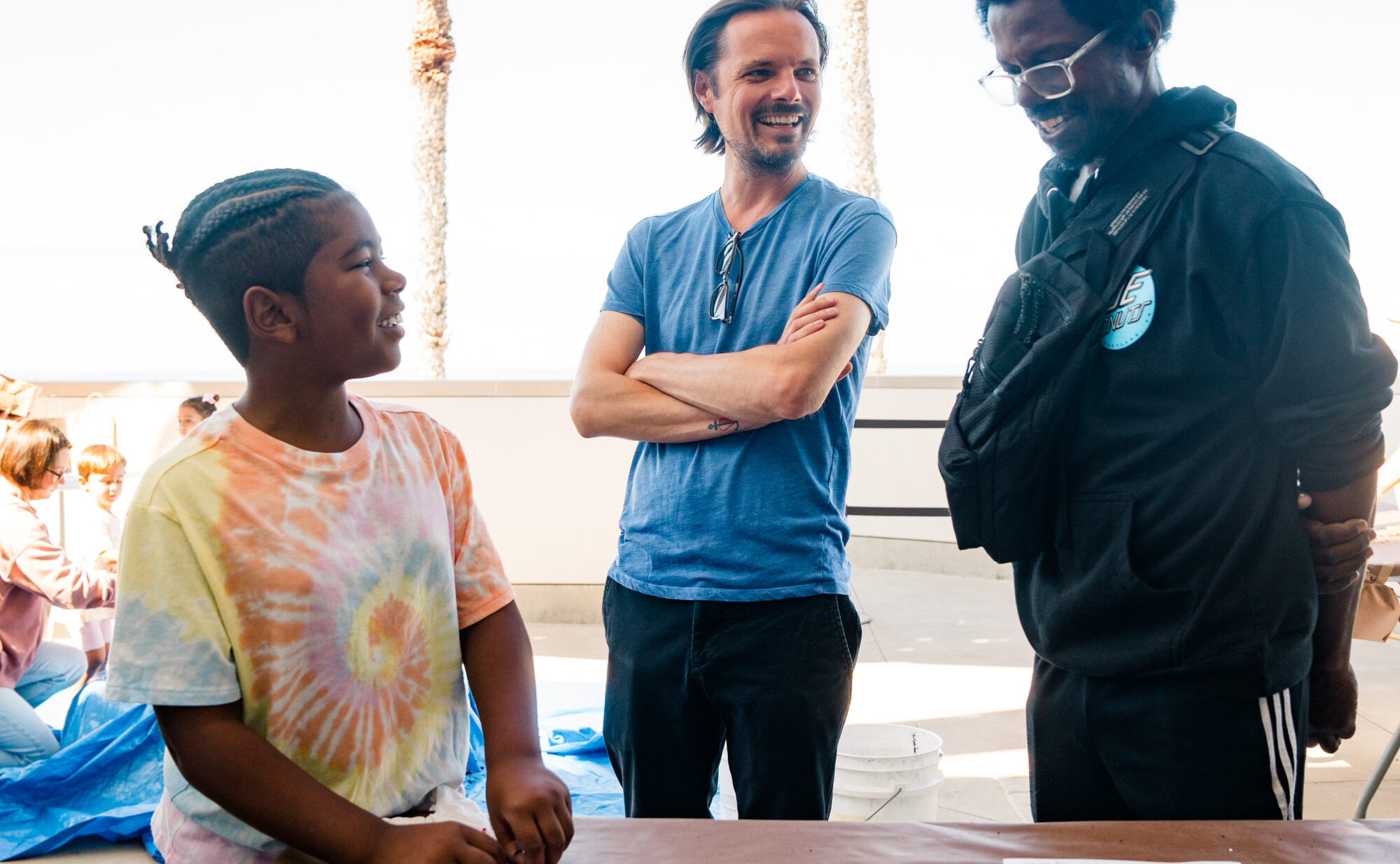 A kid and two adults making art together.