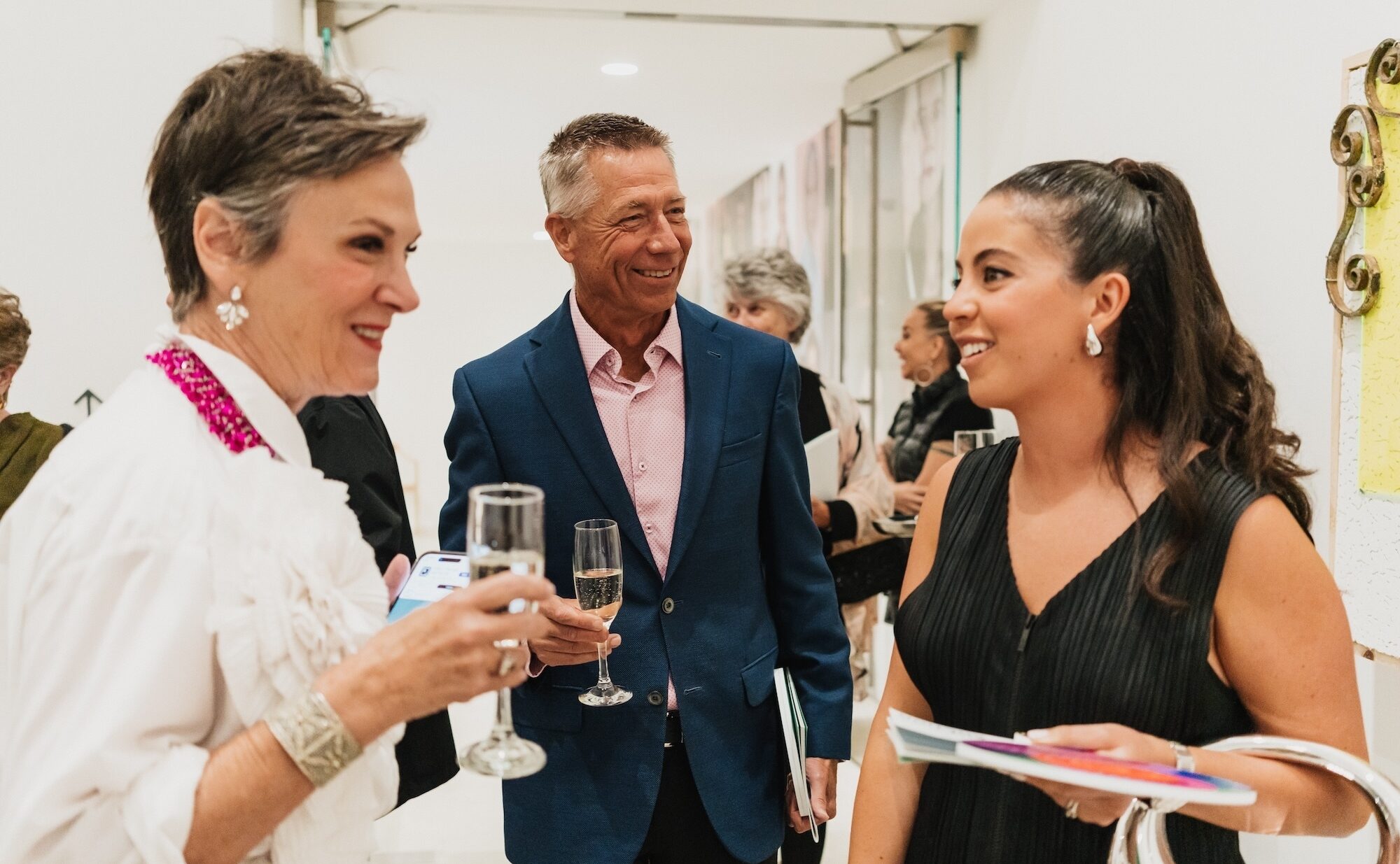 Three people mingling in the gallery.