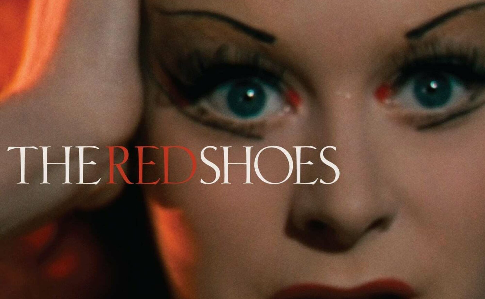 Movie poster for The Red Shoes showing a woman holding on to her hair, staring toward the viewer