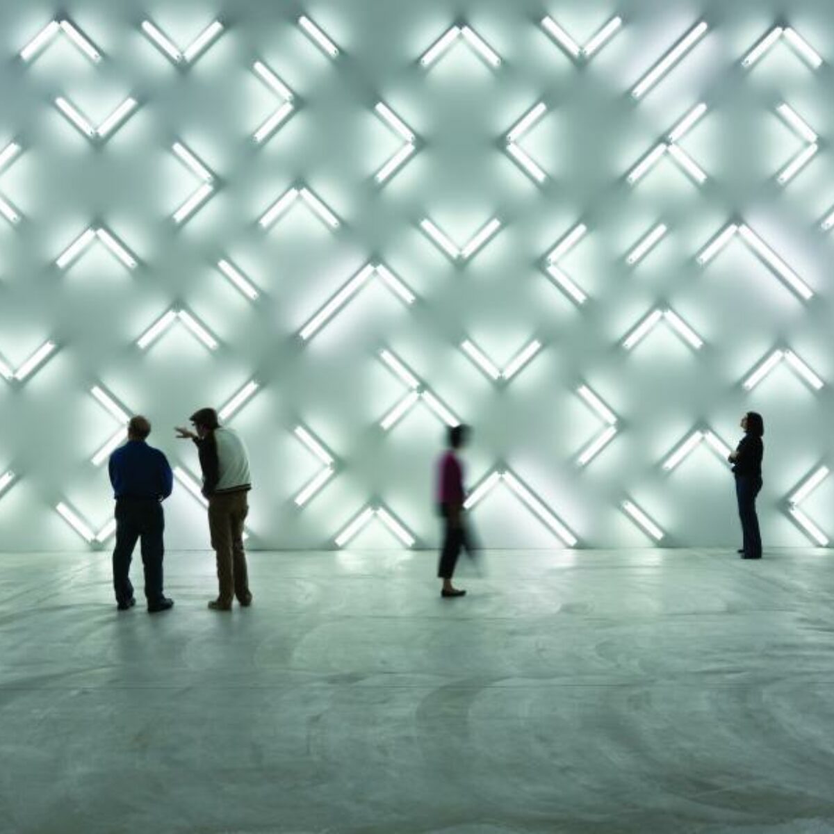 Irwin Light Space. Viewers stand in empty space, absorbing bright lights that beam off the wall.