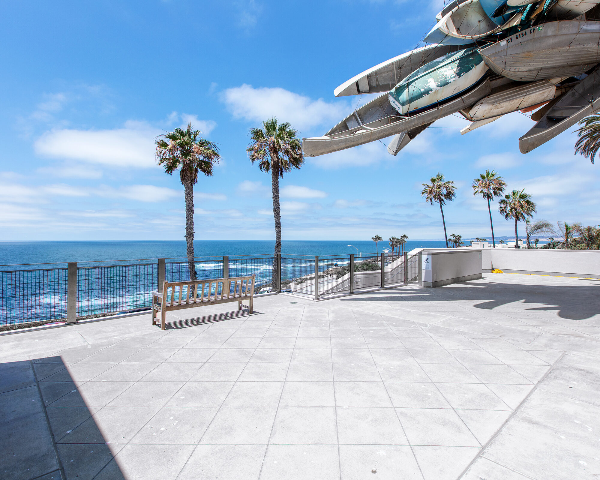 Ocean view from a grey terrace with palm trees