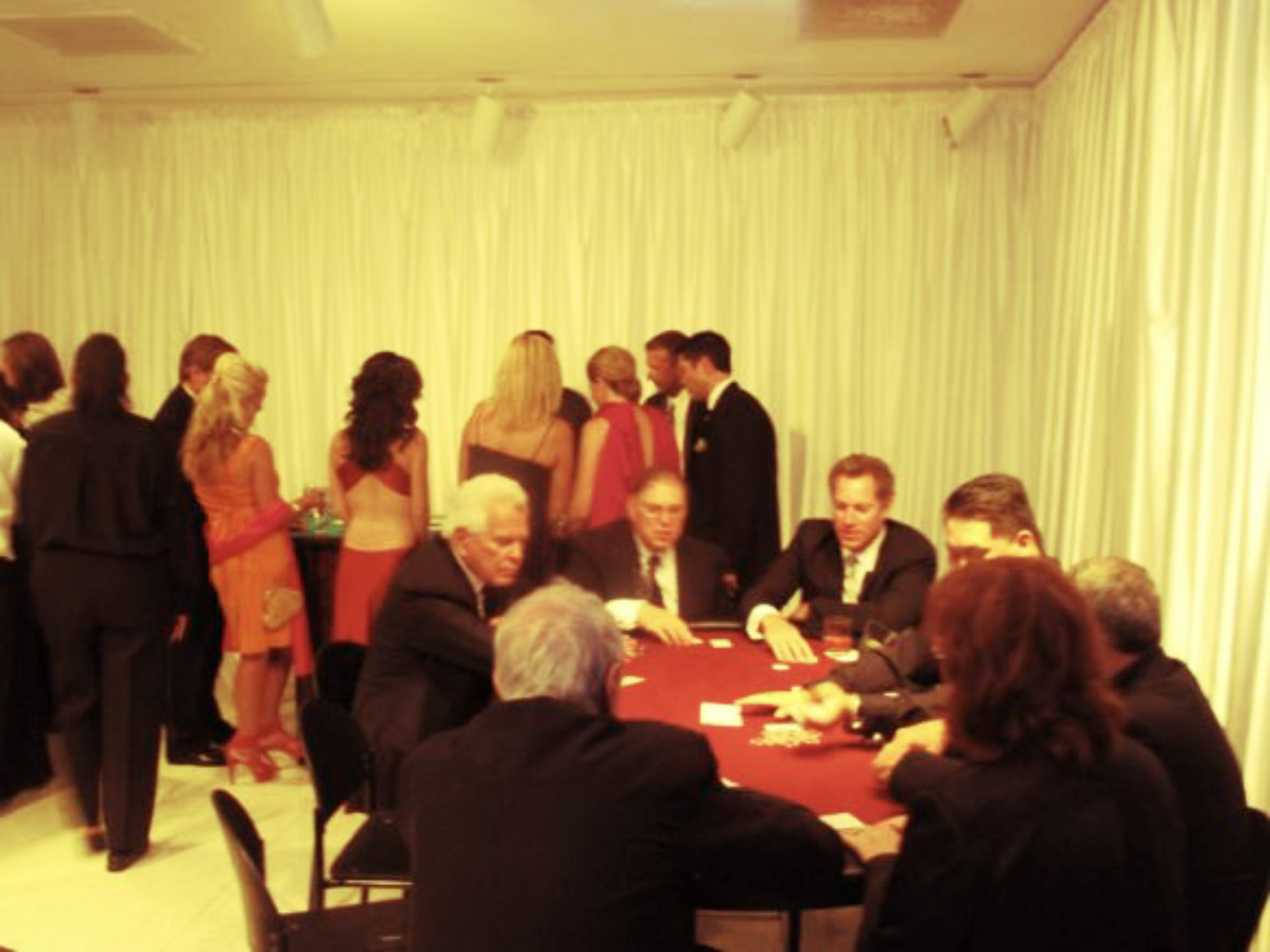 A group of men converse in table, while others stand in line at buffet.