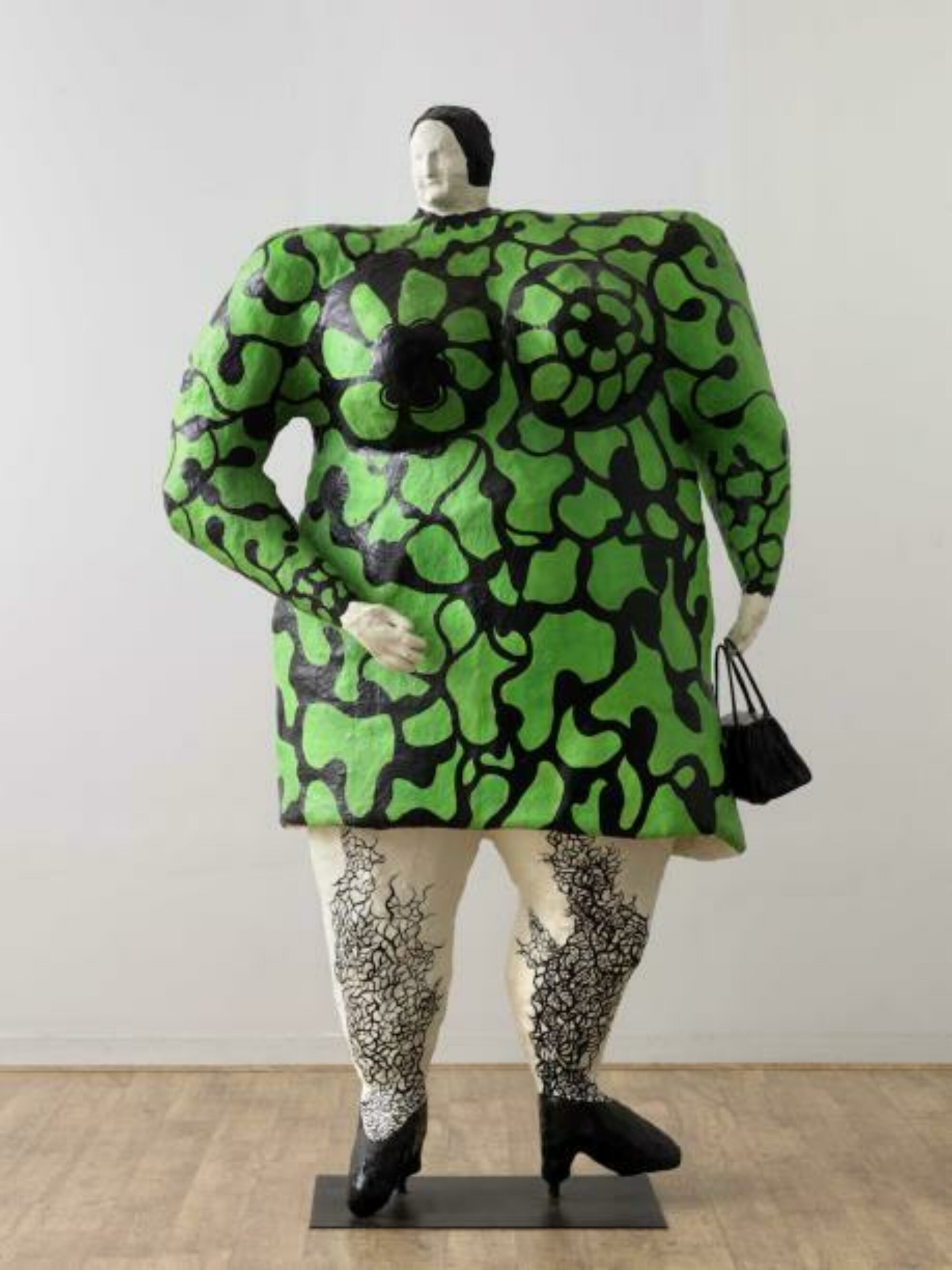 Sculpture of Nana wearing a green dress, black heels and purse.