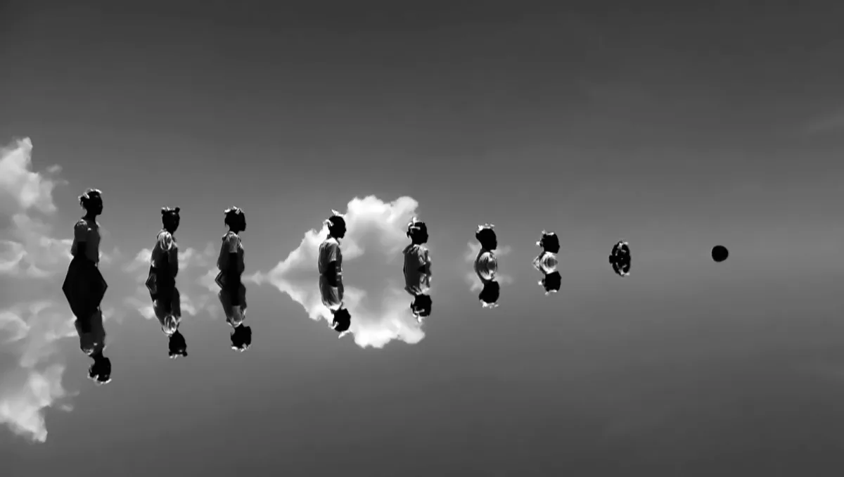 Black and white image nine people lined up in a body of water-- bodies are more submerged in the water from right to left